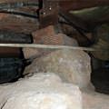 A crawl space support consisting of a rock and wood shimming in a Augusta home