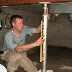 A contractor in Chapin installing a crawl space jack post.