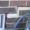A closeup of a failed tuckpointing job where the brick cracked on a Camden home.