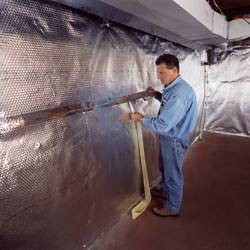 Installation of a radiant heat and vapor barrier on a basement wall in Goose Creek