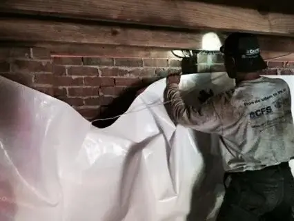 One of crew members begins encapsulating the crawl space with CleanSpace.