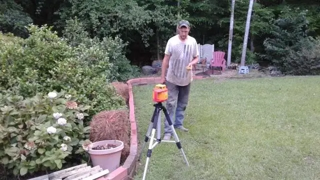 Production Crew Member Justin Wheeler is utilizing the laser equipment to show any settlement on the exterior of the house.  It is also used to show when the home is back to level after the push pier installation.