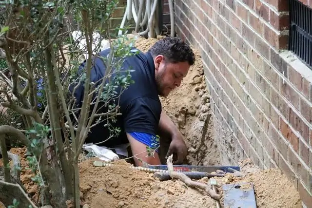 Production Team Leader Juan Ramirez installs the bracket to the footing of the foundation.
