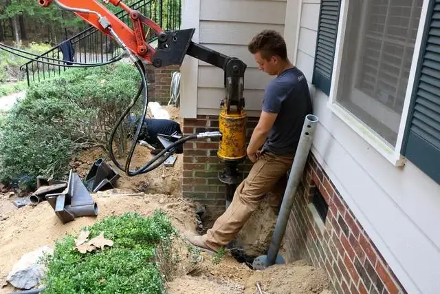 Production Team Member Robert Gardner watches to make sure the Helical Pier is being drilled properly.